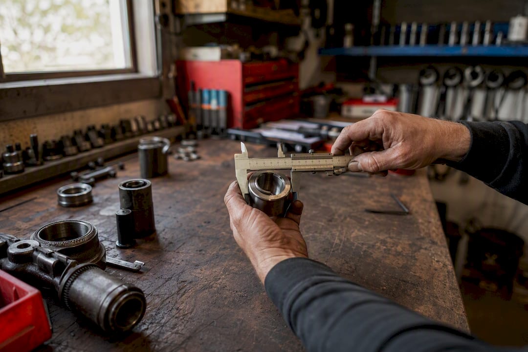 Hands using caliper measuring metal part