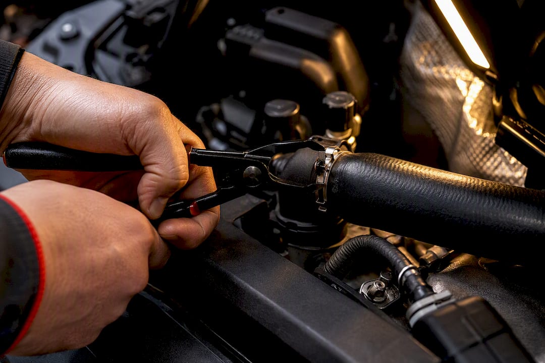 Mechanic using hose clamp pliers